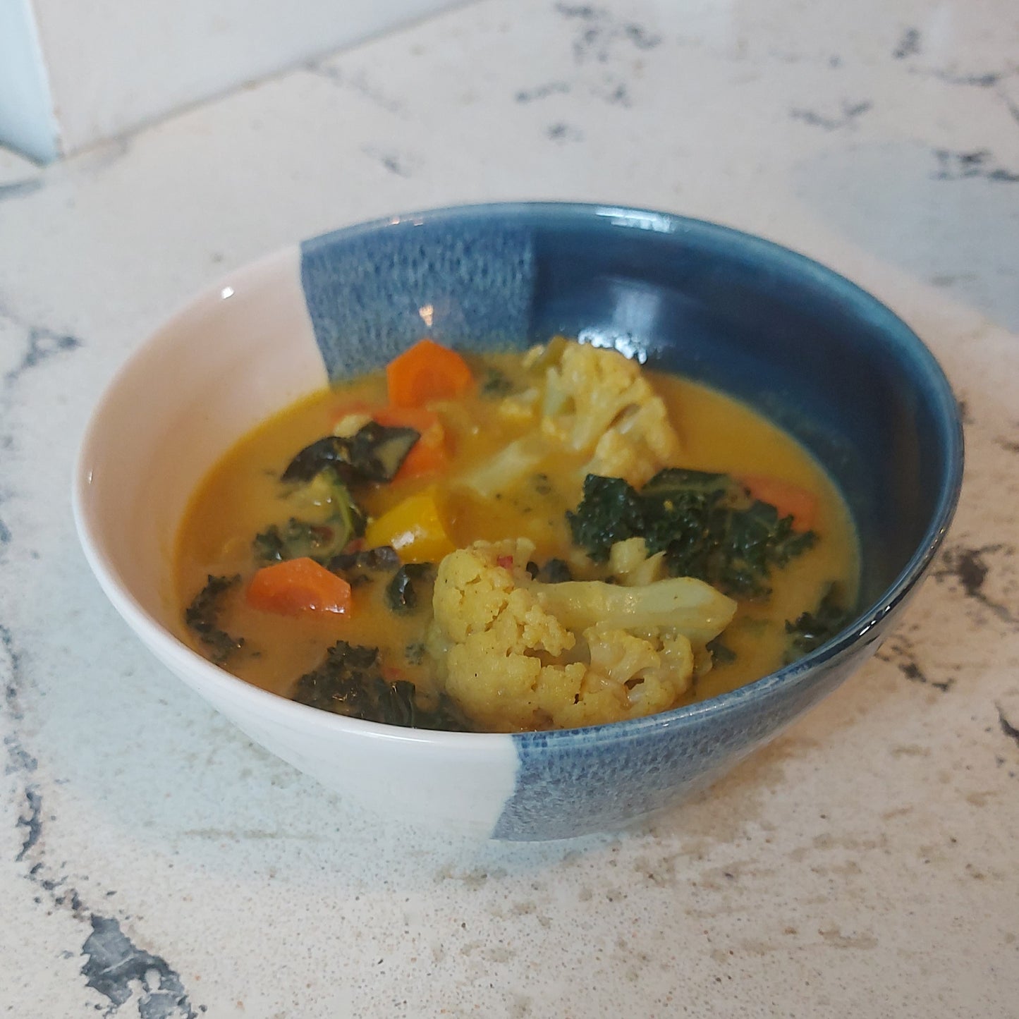 Blue and white handmade cereal bowl with curry inside